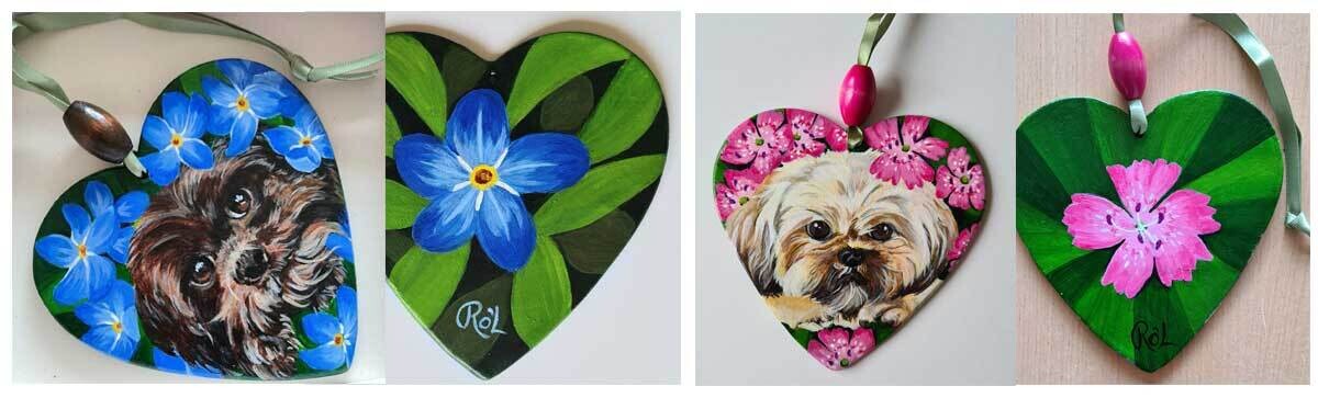 A couple of commissions of dogs surrounded with flowers painted on clay hearts